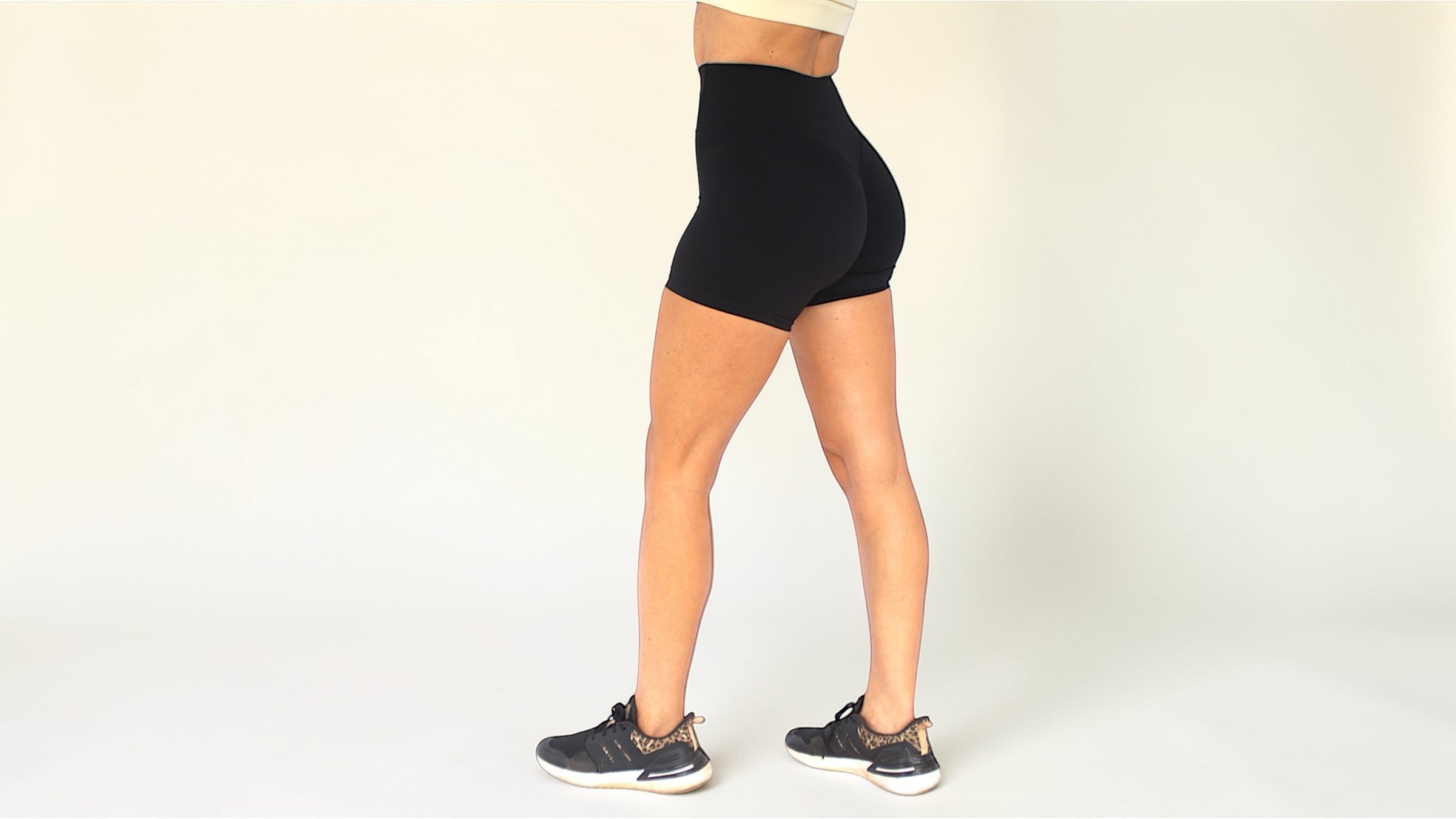 Person wearing black high-waisted shorts on a plain background