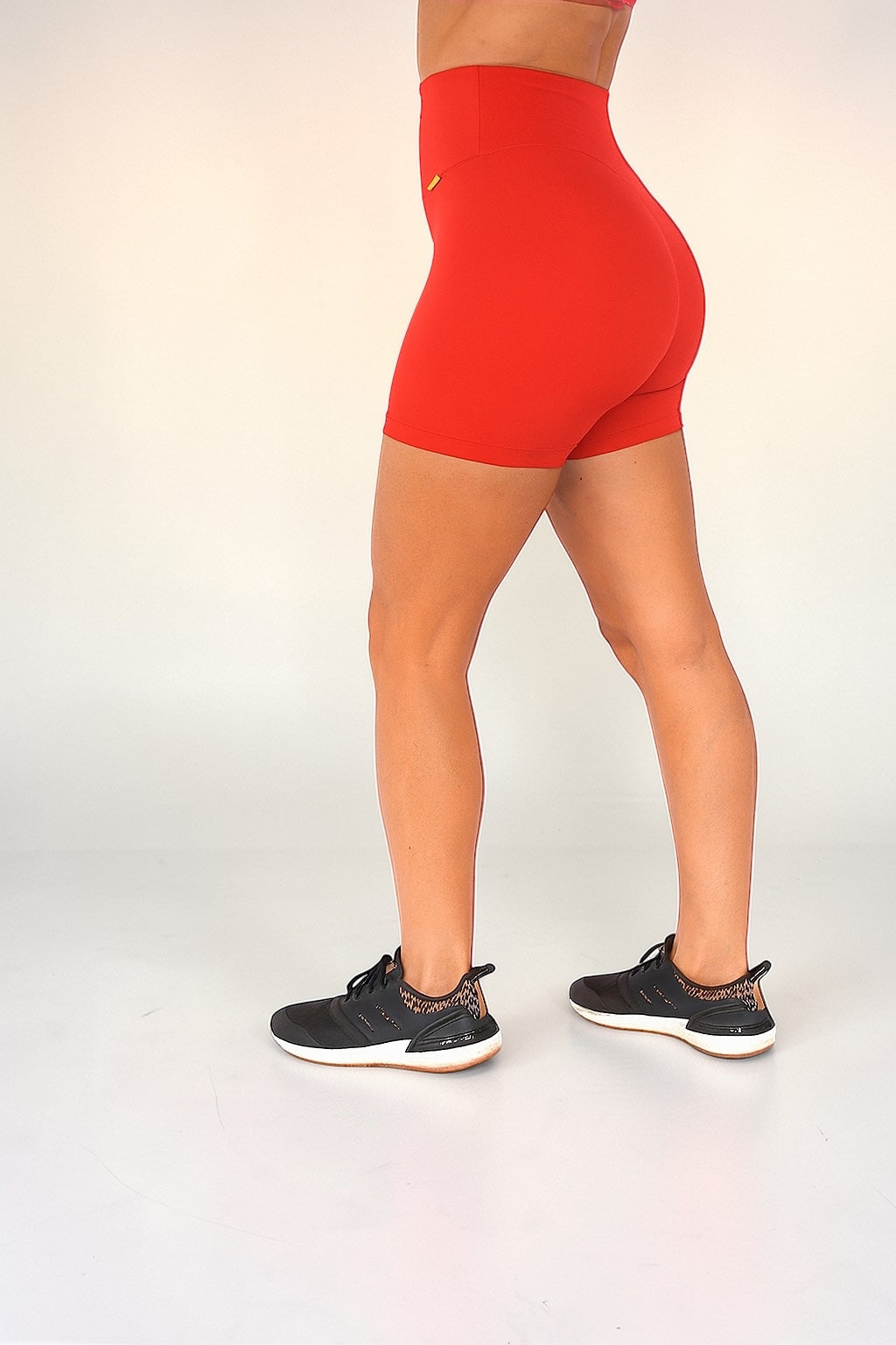 Person wearing red high-waisted shorts on a white background