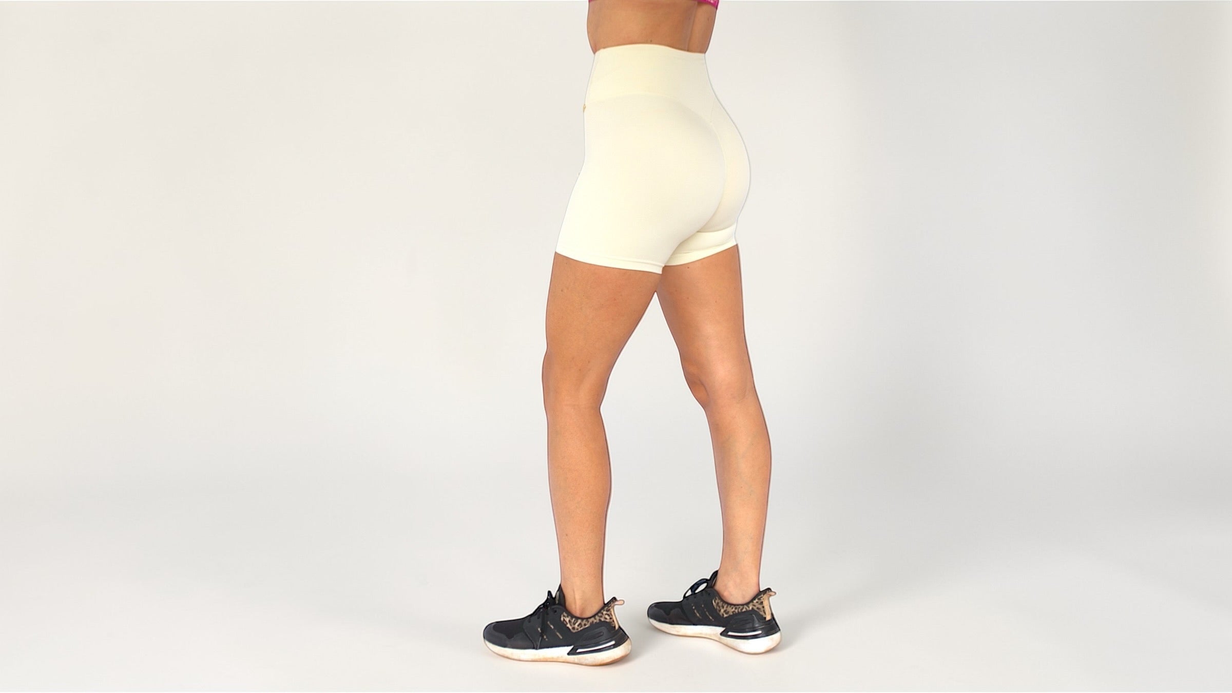Person wearing cream high-waisted shorts on a white background